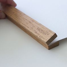 a hand holding a piece of wood with the word zoom on it and writing on it