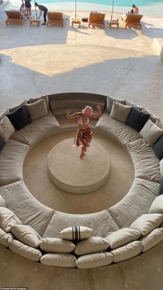 a person standing in the middle of a circular couch