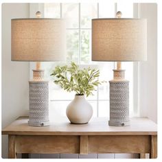 two lamps sitting on top of a table next to a vase with flowers in it