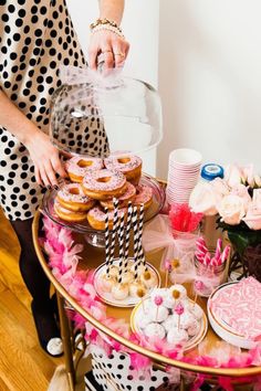 a table topped with lots of donuts and cupcakes on top of it