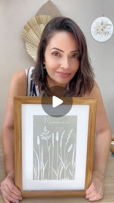 a woman holding up a framed photo in front of her face