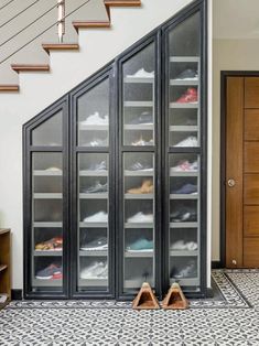 a pair of shoes sitting on top of a tiled floor next to a wooden door