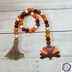 an orange and white beaded necklace with a turkey decoration on it's side