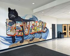 an empty school hallway with a mural on the wall