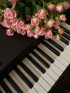 pink roses sitting on top of a piano