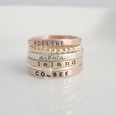 -the Laurel- Stackable Name Ring Set THIS STACKABLE NAME RING SET INCLUDES ALL OF THE RINGS IN THE FIRST PHOTO - a 2 mm rose gold filled name ring in uppercase thin block font - a 2 mm yellow gold filled beaded ring - a 2 mm fine silver name ring in lowercase cursive font - a 2 mm yellow gold filled name ring in lowercase typewriter font - a 1 mm sterling silver clear cz ring - a 2mm rose gold filled name ring in uppercase bold block font These are separate rings and can be put in any order SIX Name Rings Personalized, Jewelry Mixed Metals, Personalized Stackable Rings, Stackable Name Rings, Grandmother Jewelry, Stackable Ring Sets, Name Ring, Sterling Silver Stacking Rings, Family Names