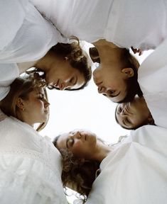 four women standing in a circle looking up