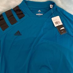 Adidas Teal X-Large Short Sleeve Jersey Like Shirt With Tags. Never Worn Adidas Sporty V-neck Tops, Adidas Blue Sporty Shirt, Sporty Adidas Blue Shirt, Adidas Blue Long Sleeve Tops, Blue Adidas Long Sleeve Tops, Adidas Blue Crew Neck Top, Blue Adidas Crew Neck Top, Adidas Blue Tops For Spring, Spring Adidas Blue Tops