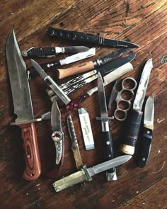 an assortment of knives on a wooden table