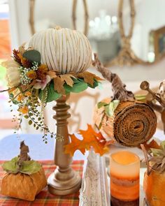 a table with candles, pumpkins and other fall decorations on top of the table