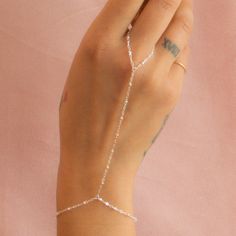 Our hand chains are a stylish piece of jewelry that connects a bracelet on your wrist to one of your fingers with delicate chains. This one is decorated with little beads, adding a unique and elegant touch. …………………………………. Details: Chain finishes 14k Gold Filled or Sterling Silver Waterproof and can be worn everyday Average bracelet size is 6.5" - 7" About Your Jewelry If you are not wearing your jewelry it is best to store it in a cool, dry place such as your gift box that is included in your or Dainty Adjustable Bracelet Body Jewelry, Dainty Adjustable Body Jewelry Bracelet, Adjustable Delicate Chain Body Jewelry As Gift, Adjustable Dainty Body Jewelry, Adjustable Delicate Chain Body Jewelry For Gift, Adjustable Delicate Chain Body Jewelry For Wedding, Adjustable Delicate Body Chain, Delicate Silver Body Chain For Party, Lariat Body Jewelry With Adjustable Chain As Gift