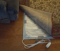 a laptop computer sitting on top of a wooden floor next to a couch and rug