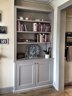 a book shelf with books and vases on it