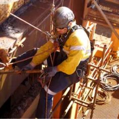 a man climbing up the side of a building with ropes and harnesses attached to it