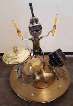 a musical instrument sitting on top of a gold plate with two yellow sticks sticking out of it