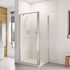 a white bathroom with a walk in shower next to a sink and toilet on the side