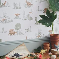 a potted plant sitting on top of a wooden table next to a wall paper