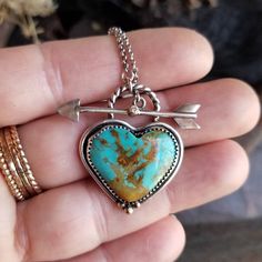 "Genuine Kingman, Arizona turquoise heart is set in a handcrafted oxidized 925 sterling silver bezel with accents of 14k gold. Front closing arrow toggle closure features a Moissanite diamond for a touch of sparkle. Connects  to a 1.5mm lightweight and sturdy rolo chain.  ~Heart pendant in main listing pictures is sold. Please choose B or C to be set for you! ~1.25\" x 1\" heart pendant  ~Wrapped in black gift box ~Handmade in Tennessee" Turquoise Jewelry Rings, Turquoise Heart Necklace, Key Charm Necklace, Kingman Arizona, Vintage Jewelry Ideas, Into The West, Turquoise Heart, Crystal Necklaces, Arizona Turquoise