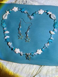 Capture the essence of beachy shores with our delightful beach-themed jewelry set! Adorn yourself with shimmering seashells and sparkling sea glass in the form of earrings, a necklace, and a stylish glasses chain. Perfect for adding a touch of seaside charm to any outfit, these pieces are your ticket to coastal bliss wherever you go <3 Ocean-inspired Beaded Jewelry, Beaded Shell-shaped Jewelry For The Beach, Shell-shaped Beaded Jewelry For Beach Season, Beaded Sea Glass Jewelry For Beach, Beach Beaded Sea Glass Jewelry, Ocean-inspired Jewelry With Round Beads For Beach Season, Ocean-inspired Round Beads Jewelry For Beach Season, Beach Jewelry With Beaded Ocean Color, Ocean Blue Beaded Jewelry For Beach