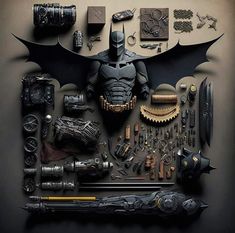 an assortment of batman memorabilia is displayed on a black surface with the bat symbol above it