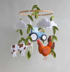 a mobile with a tractor, farm animals and clouds hanging from it's sides