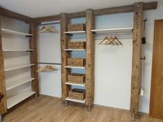 an empty closet with wooden shelves and baskets