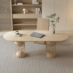 a table with a laptop on it in front of a bookshelf and shelves