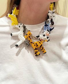 a woman wearing a white t - shirt with yellow and black beads on her neck