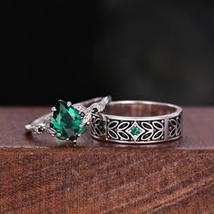 two silver rings with green stones on them