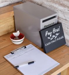 a desk with a notepad, pen and paper on it next to a mailbox