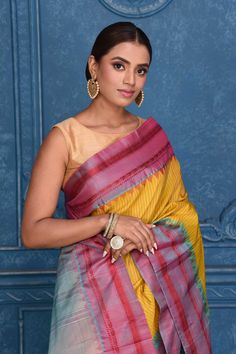 Look your best on festive occasions in this beautiful yellow striped pure Gadhwal silk saree. The saree is enhanced with bluish pink border and zari pallu. It comes with a matching blouse piece. Disclaimer: The shown stitched blouse on the model is for display purpose only. The saree comes with a matching blouse piece and finished with fall and piko. Yellow Handloom Pre-draped Saree For Navratri, Yellow Tussar Silk Pre-draped Saree For Diwali, Festive Yellow Paithani Silk Pre-draped Saree, Yellow Banarasi Silk Traditional Wear With Border Detail, Festive Yellow Traditional Wear With Border, Yellow Katan Silk Saree With Border, Yellow Katan Silk Dupatta With Border, Yellow Banarasi Silk Saree With Border, Yellow Katan Silk Traditional Wear With Border