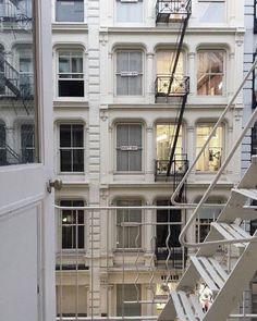 a fire escape in the middle of a building with stairs leading up to two stories