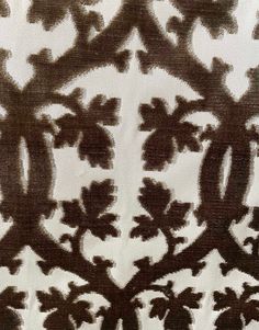 an intricately designed piece of cloth with brown and white designs on the fabric,