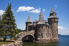 an old castle sits on the edge of a body of water