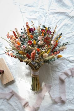 a bouquet of flowers sitting on top of a white sheet