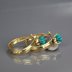 This unique and powerful design of golden crown hoop earrings came out of a session in my studio when the flattened gold filled material had been accidentally folded on both sides. The gold filled was flattened and created a rustic, ancient look that would've blended beautifully when the Aztecs were once in power.Turquoise howlite golden crown hoop earrings would be a perfect compliment for a wedding party or as a wedding gift.The earring's backs are handmade and have a very useful and comfortab Turquoise Metal Hoop Earrings, Elegant Turquoise Hoop Earrings, Turquoise Hoop Metal Jewelry, Turquoise Hoop Earrings With Natural Stones, Turquoise Metal Hoop Jewelry, Turquoise Natural Stone Hoop Earrings As Gift, Turquoise Hoop Earrings With Natural Stones As Gift, Turquoise Hoop Jewelry, Turquoise Metal Round Hoop Earrings