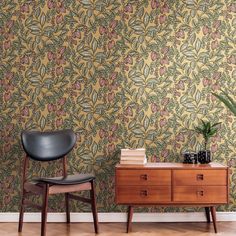 a chair and table in front of a wallpapered room