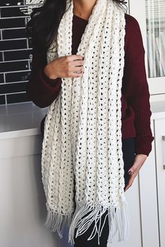 a woman wearing a white knitted scarf