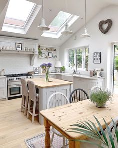 a kitchen filled with lots of white appliances and wooden table next to a stove top oven