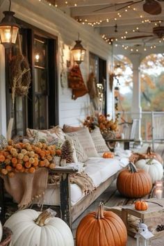 a porch decorated for fall with pumpkins and other decorations