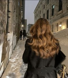 a woman walking down a snow covered street