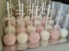 a box filled with cake pops covered in white and pink frosting