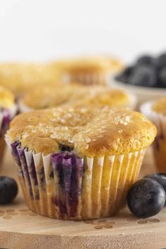 blueberry muffins on a cutting board with fresh blueberries