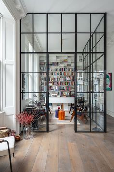 an office with glass walls and wooden floors