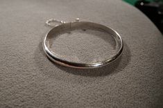 I am offering you this fabulous vintage sterling silver (stamped) eternity design bangle bracelet. The entire surface is curve domed and very sleek, it measures approx. 2.5 inches in diameter, it has a very secure slide insert safety locking closure, as well as an additional safety chain. This you on on high end pieces of jewelry. Buyer pays shipping and handling. Silver Bangle Bracelet, Sterling Silver Bangle Bracelets, Sterling Silver Bangle, Safety Chain, Rochester Ny, Sterling Silver Bangles, Silver Bangle, Art Deco Style, Style Classic