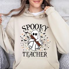 Spooky Teacher Hoodie, Halloween Ghost Teacher Hoodie, Pencils Bats Teacher Hoodie, Read More Hoodie, Gift Fall Teacher Hoody, teacher Hoody Welcome to TrendswayStore! You are where you can find your style and comfort. We are here to introduce you to the latest trends and quality products. Start exploring now We wish you pleasant shopping! PRODUCT DETAILS -Fit: Relaxed fit, suitable for both men and women (unisex). -Material: Made from 50% cotton and 50% polyester. -Ribbing: 1 x 1 rib with spandex, likely on the cuffs and waistband for better stretch and recovery.- -Hood: Double-lined hood for extra warmth and durability. -Drawcord: Color-matched drawcord for adjusting the hood (note: for youth hoodies, the drawcord is typically omitted for safety reasons). -Pocket: Pouch pocket on the fro Casual Wear Women, Letter Print Hoodie, Winter Mode, Cozy Pullover, Active Hoodie, Halloween Ghost, Print Pullover, Casual Pullover, Casual Hoodie