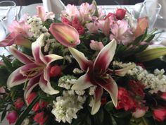 a vase filled with lots of flowers on top of a white tablecloth covered table