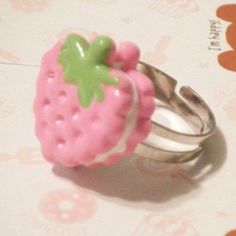 a close up of a ring with a strawberry on it