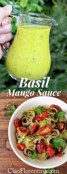 a bowl filled with pasta and sauce next to a glass pitcher full of pesto sauce