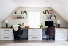 an attic office with two desks and chairs